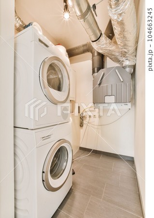 a laundry room with washer and dryer in the corner, which has been used as a storage space 104663245