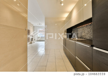 a modern kitchen with tile flooring and white tiles on the walls, in an open space that has been used for many years 104663559