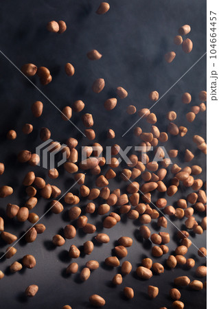 Peanut flying explosion, brown grain peanuts explode abstract cloud fly. Beautiful complete seed pea peanut splash in air, food object design. Selective focus freeze shot black background isolated 104664457