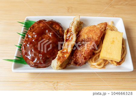 Japanese hamburger steak, fried fish and Japanese rolled omelet on white plate Japanese hamburger steak, fried fish and Japanese rolled omelet on white plate 104666328