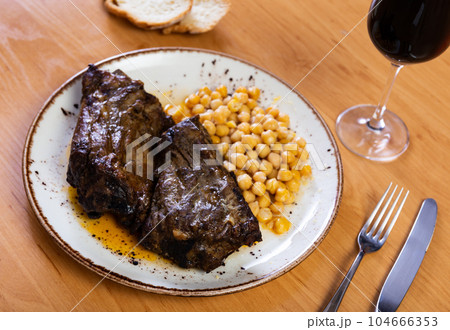 Roast whole pork knuckle served with chickpea on plate closeup Roast whole pork knuckle served with chickpea on plate closeup 104666353