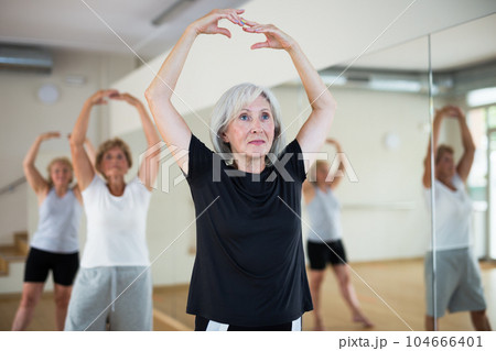 Aged women performing ballet dance in fitness room 104666401