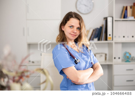 Portrait of therapist woman who is standing on her workplace in clinic 104666488