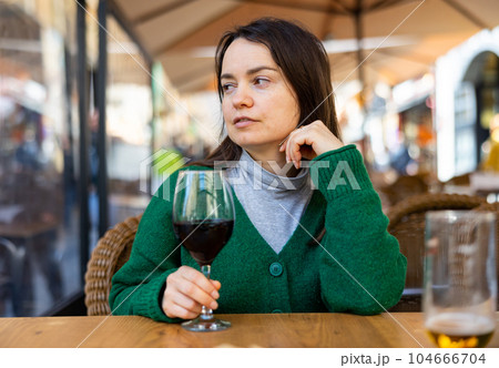 Young adult woman drinking wine at restaurant 104666704