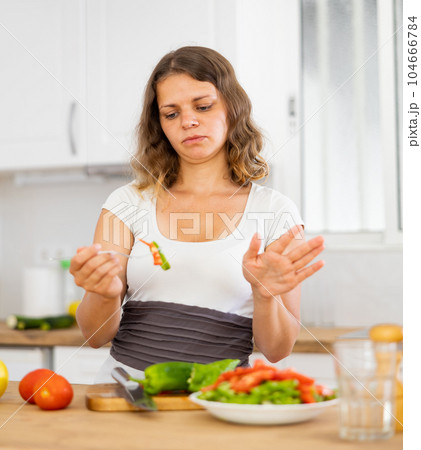 Woman not satisfied with prepared salad Woman not satisfied with prepared salad 104666784