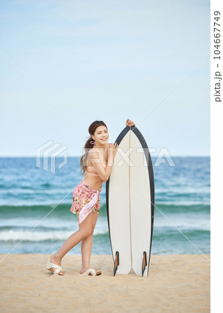 woman holding surfboard at beach 104667749