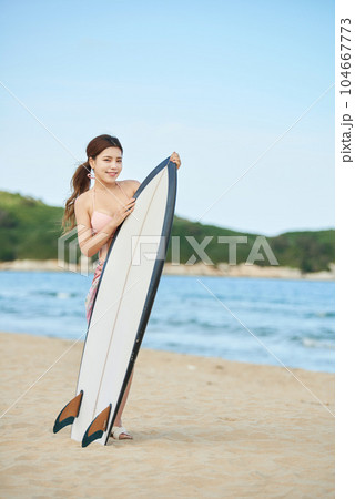 woman holding surfboard at beach 104667773