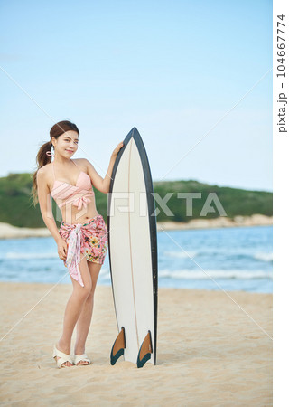 woman holding surfboard at beach 104667774