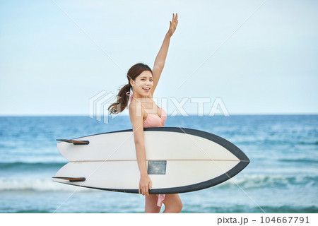 woman holding surfboard at beach 104667791