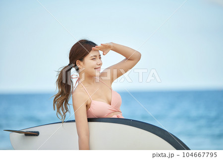 woman holding surfboard at beach 104667795