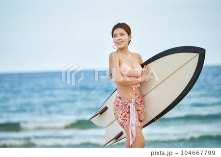 woman holding surfboard at beach 104667799