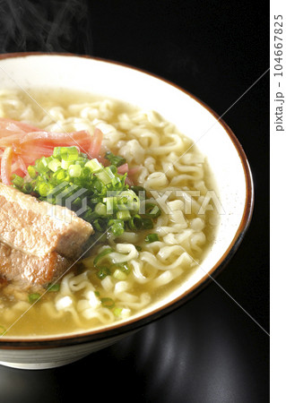 豚のバラ肉とたっぷりの小ねぎと紅生姜入りの熱々沖縄そばを黒背景で撮影 104667825