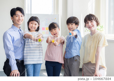 教育　英会話教室でレッスンを受ける子供と講師のポートレート 104667884