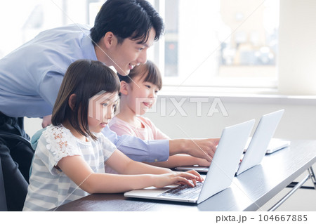 パソコンで学習する子供と講師 パソコンで学習する子供と講師 104667885