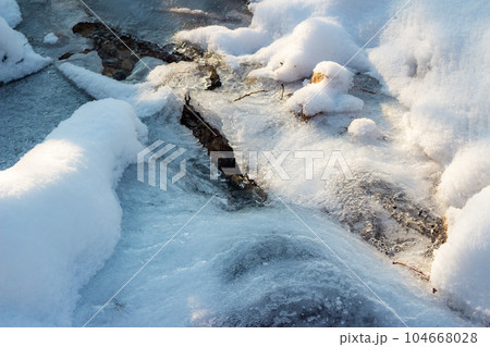 Ice buildup on a frozen river in winter 104668028