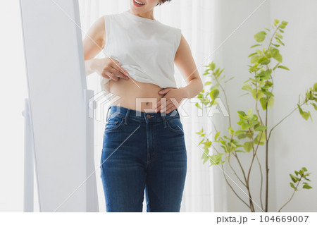 鏡でお腹をチェックする女性 鏡でお腹をチェックする女性 104669007