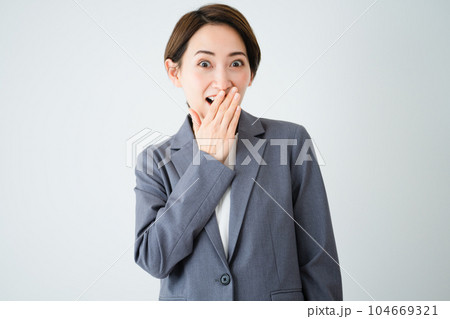 驚いて口に手を当てる若い女性 ビジネスイメージ 驚いて口に手を当てる若い女性 ビジネスイメージ 104669321