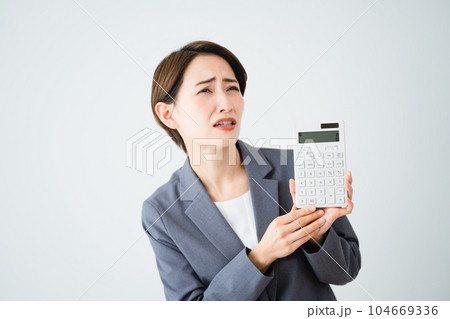 電卓を持って悩む若い女性　ビジネスイメージ	 104669336