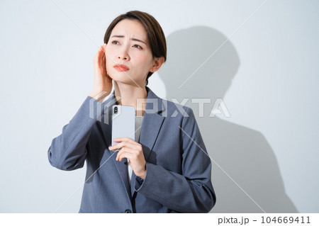 スマートフォンを持ちながら悩んでいる若い女性　ビジネスイメージ 104669411