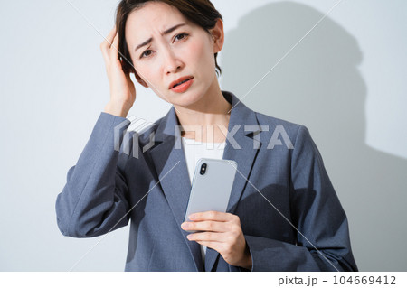 スマートフォンを持ちながら悩んでいる若い女性　ビジネスイメージ 104669412