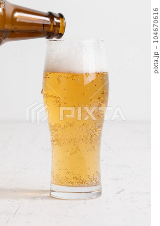 グラスに注がれるビール　beer being poured into a glass	 104670616