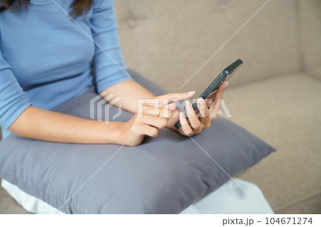 Woman checking Financial on smartphone Human hand holding mobile phone working from home 104671274