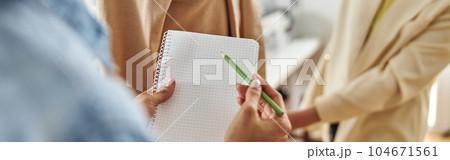 African-American woman holds blank sketchbook and green pencil w African-American woman holds blank sketchbook and green pencil w 104671561