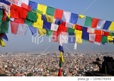 ネパールの世界文化遺産カトマンドゥ盆地　丘のチベット仏教寺院スワヤンブナートからのタルチョーと街並み 104674944