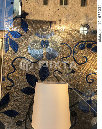 イタリア・ミラノ市内、お店のモザイクデコレーションと映り込んだ古い建築物が巧く融合した画像。 104675034