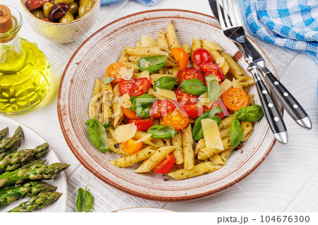 Italian pasta adorned with fresh tomatoes and aromatic basil Italian pasta adorned with fresh tomatoes and aromatic basil 104676300