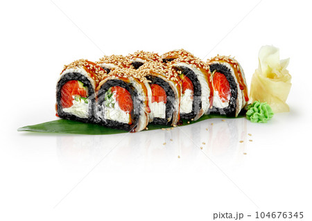 Black rice sushi rolls with salmon, eel, unagi sauce and sesame on bamboo leaf 104676345