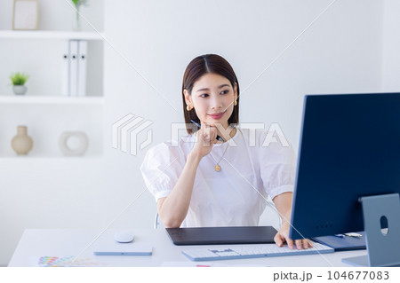 ビジネス　デスクで仕事をする女性　 104677083