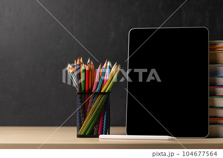 Tablet with colorful pencils and stack of books Tablet with colorful pencils and stack of books 104677564