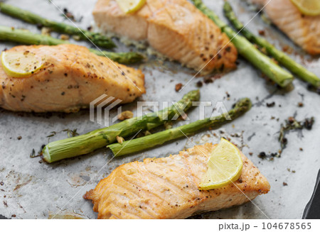 Baked Delicious salmon, green asparagus and lemon in pan 104678565