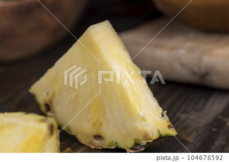 sliced ripe yellow pineapple, a large number of pieces 104678592