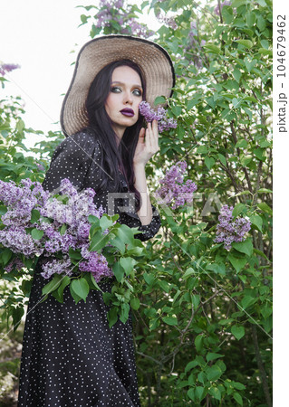 A fashionable girl with dark hair, a spring portrait in lilac tones in summer. Bright professional makeup. A fashionable girl with dark hair, a spring portrait in lilac tones in summer. Bright professional makeup. 104679462