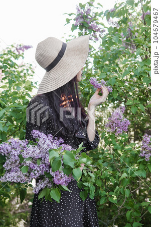A fashionable girl with dark hair, a spring portrait in lilac tones in summer. Bright professional makeup. A fashionable girl with dark hair, a spring portrait in lilac tones in summer. Bright professional makeup. 104679467