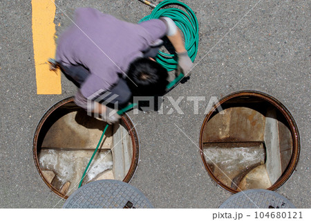 マンション内の排水マスを高圧洗浄する作業シーン マンション内の排水マスを高圧洗浄する作業シーン 104680121