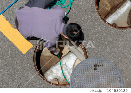 マンション内の排水マスを高圧洗浄する作業シーン 104680126