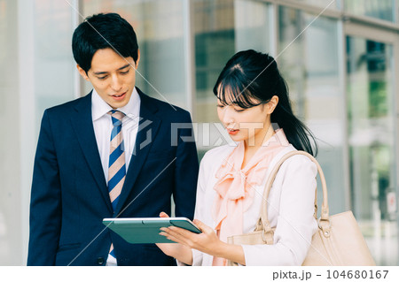 ビジネスでタブレットを見る男女会社員 ビジネスでタブレットを見る男女会社員 104680167