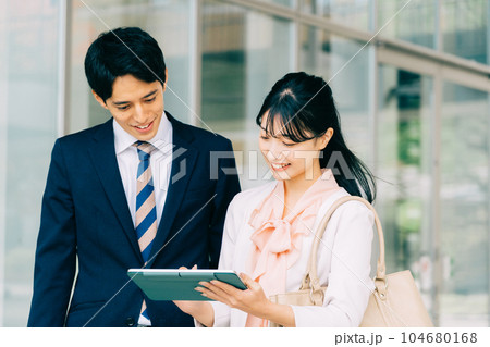 ビジネスでタブレットを見る男女会社員 104680168