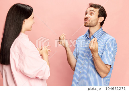 Emotional man talking to woman, discussing news and rumors against pink studio background. Lively conversation Emotional man talking to woman, discussing news and rumors against pink studio background. Lively conversation 104681271
