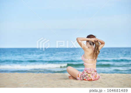 young woman in swimsuit posing on beach 104681489