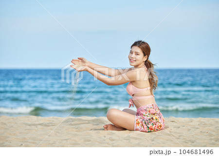 young woman in swimsuit posing on beach 104681496