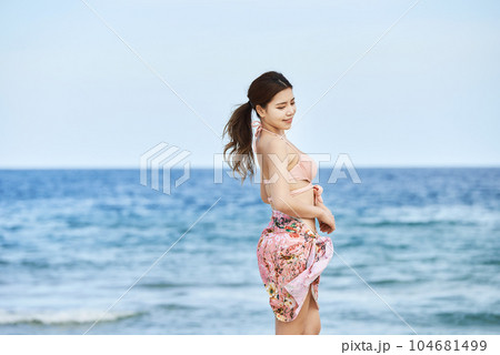 young woman in swimsuit posing on beach 104681499