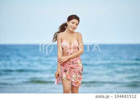 young woman in swimsuit posing on beach 104681512