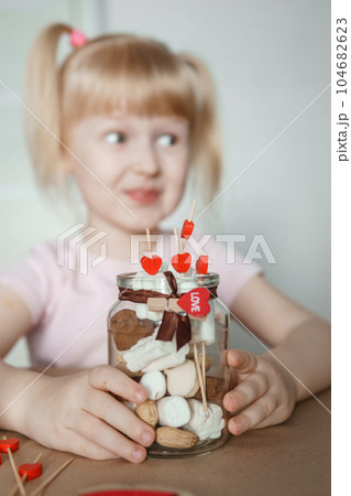 A little girl blogger makes a sweet Valentine's Day gift with her own hands. A gift for the holiday, a video blog entry. 104682623