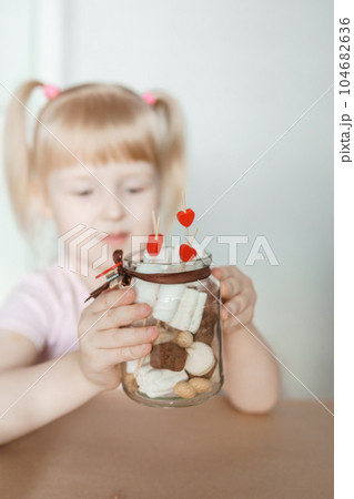 A little girl blogger makes a sweet Valentine's Day gift with her own hands. A gift for the holiday, a video blog entry. 104682636