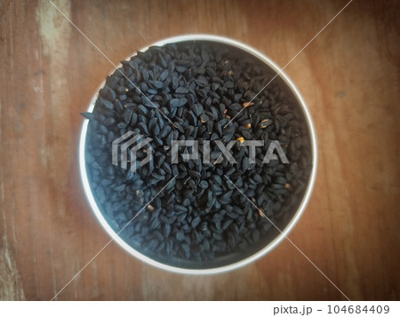 Flatlay shot of black seed nigella sativa on plate 104684409