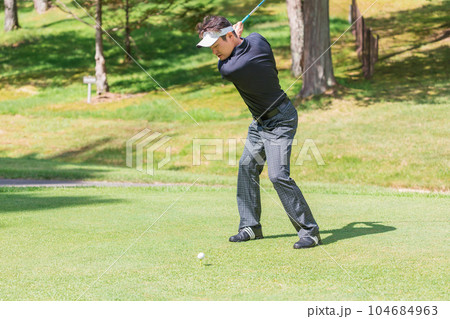 ゴルフ場でゴルフをするゴルファーの男性 104684963